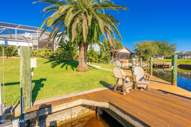 view of dock with a yard and a water view