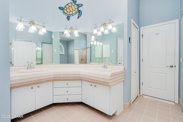 bathroom with a sink, a shower stall, and tile patterned floors