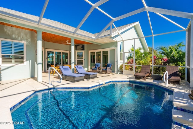 outdoor pool featuring a patio, ceiling fan, and glass enclosure