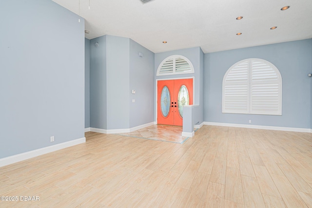 foyer entrance featuring baseboards, recessed lighting, light wood-style floors, and french doors