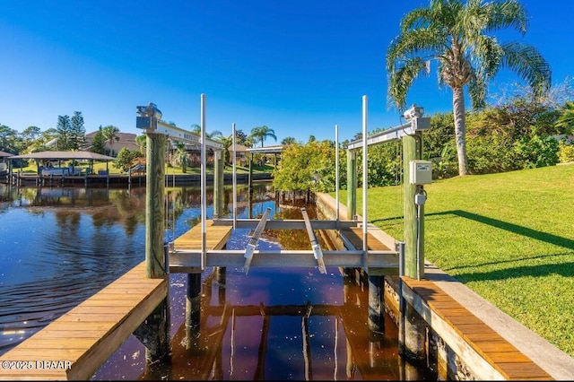 dock area featuring boat lift, a yard, and a water view
