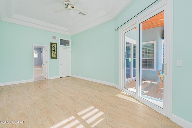 unfurnished room with visible vents, ceiling fan, a wealth of natural light, and wood finished floors