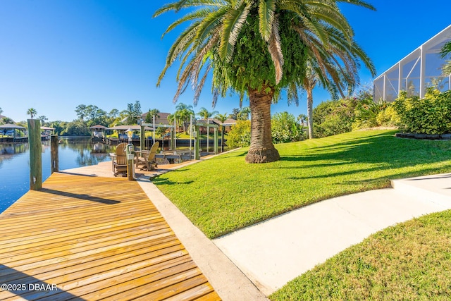 view of dock featuring boat lift, a lanai, a yard, and a water view