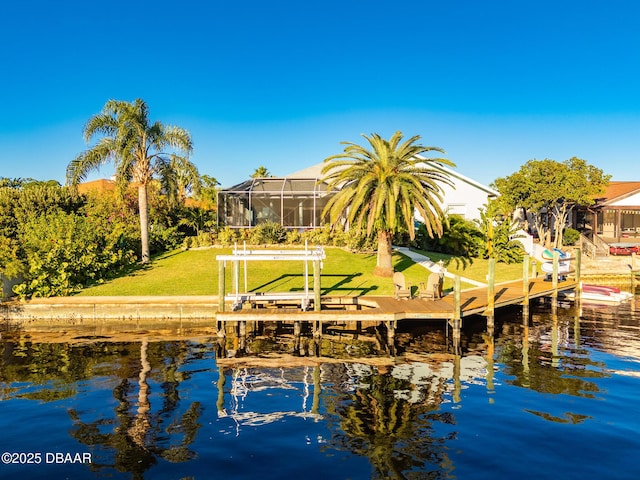 dock area with a yard, a water view, boat lift, and glass enclosure