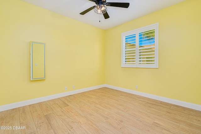 unfurnished room with baseboards, wood finished floors, and a ceiling fan