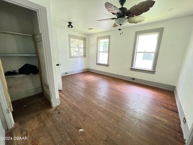 unfurnished bedroom featuring ceiling fan, dark hardwood / wood-style flooring, and a closet