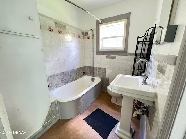 bathroom with tiled shower / bath combo, hardwood / wood-style flooring, toilet, and tile walls