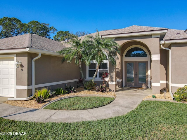 exterior space featuring french doors, a garage, and a front lawn