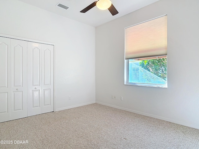 unfurnished bedroom with carpet, ceiling fan, and a closet