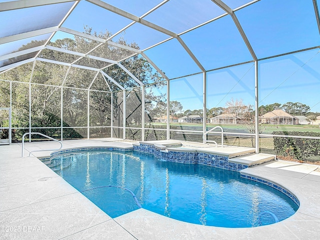 view of pool featuring a hot tub, a patio area, and glass enclosure