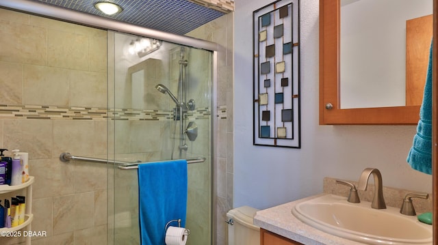full bath with vanity, a shower stall, and toilet