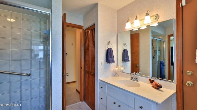 bathroom featuring a closet, tile patterned flooring, vanity, and a shower stall