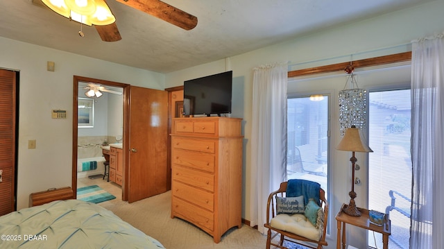 bedroom featuring light colored carpet, a ceiling fan, and ensuite bath