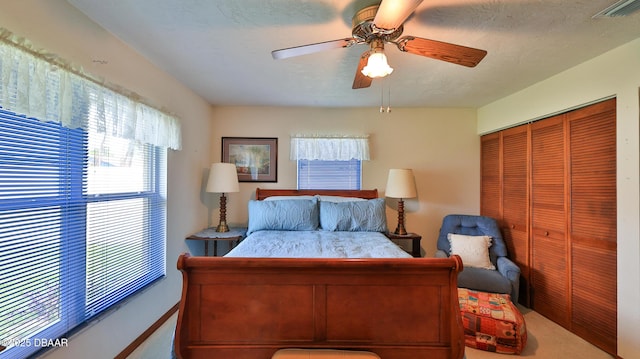carpeted bedroom with a ceiling fan, visible vents, and a closet