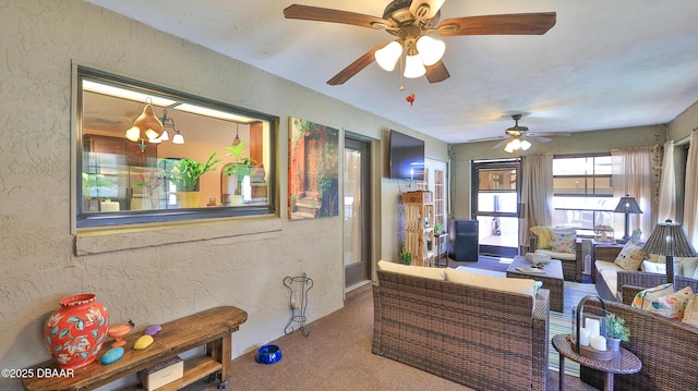 carpeted living area featuring a ceiling fan and a textured wall