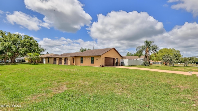 ranch-style house featuring an attached garage, a front lawn, fence, and driveway