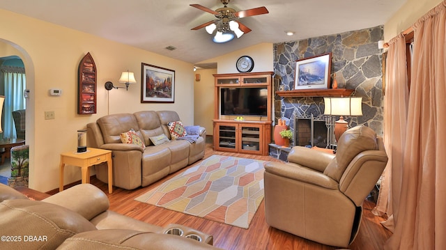 living area featuring ceiling fan, arched walkways, wood finished floors, lofted ceiling, and visible vents