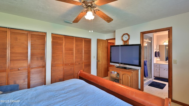 bedroom with baseboards, ceiling fan, multiple closets, and ensuite bathroom