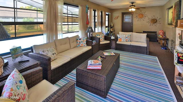 living area featuring carpet flooring and ceiling fan