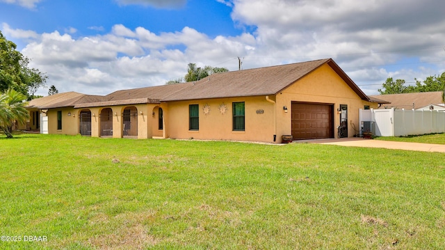 ranch-style house with a front yard, fence, concrete driveway, an attached garage, and stucco siding