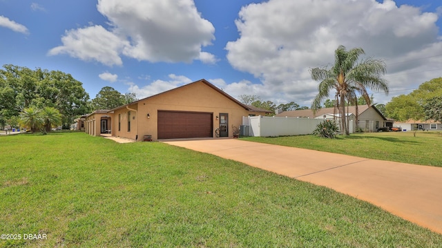 ranch-style home with driveway, fence, a front lawn, an attached garage, and stucco siding