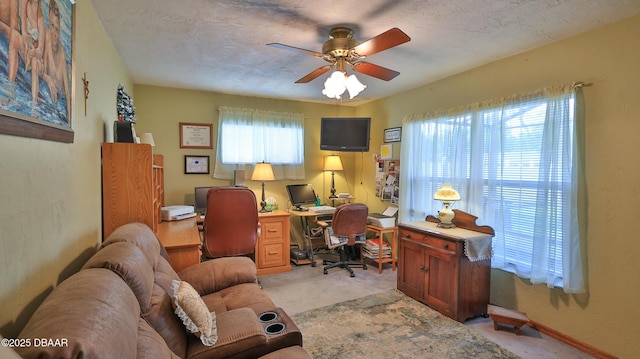 office space featuring ceiling fan and light carpet
