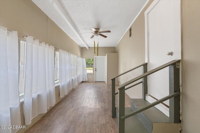 hall with hardwood / wood-style floors and a textured ceiling