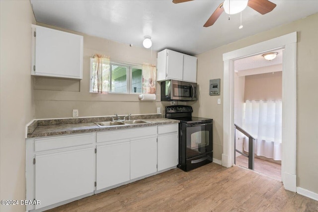 kitchen with black electric range, sink, light hardwood / wood-style floors, and white cabinets