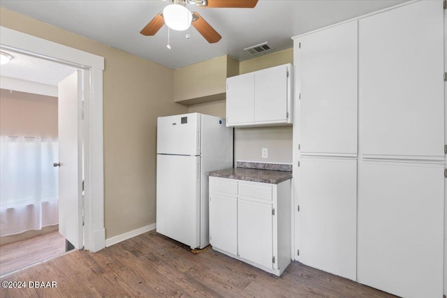 kitchen with hardwood / wood-style floors, ceiling fan, white cabinetry, and white fridge