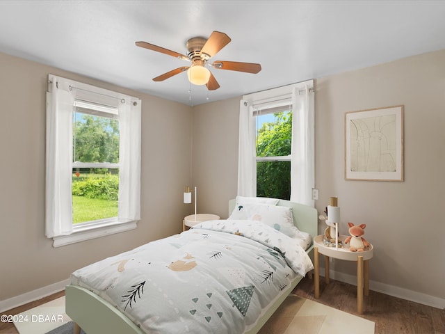 bedroom with hardwood / wood-style flooring, multiple windows, and ceiling fan