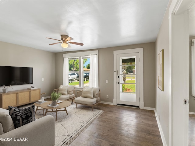 living room featuring dark wood-type flooring and ceiling fan