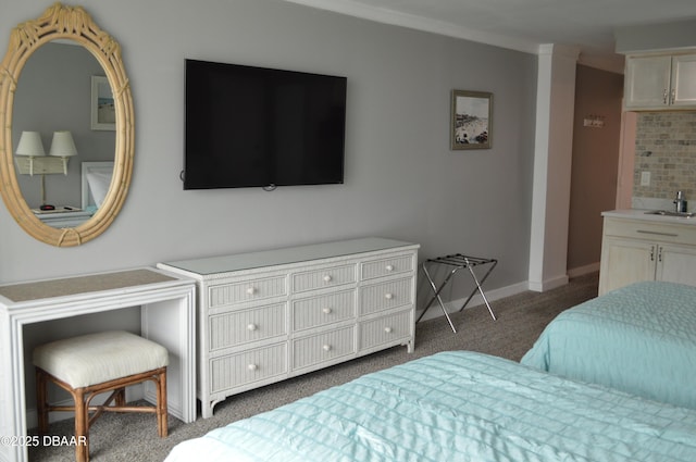 carpeted bedroom with sink and ornamental molding