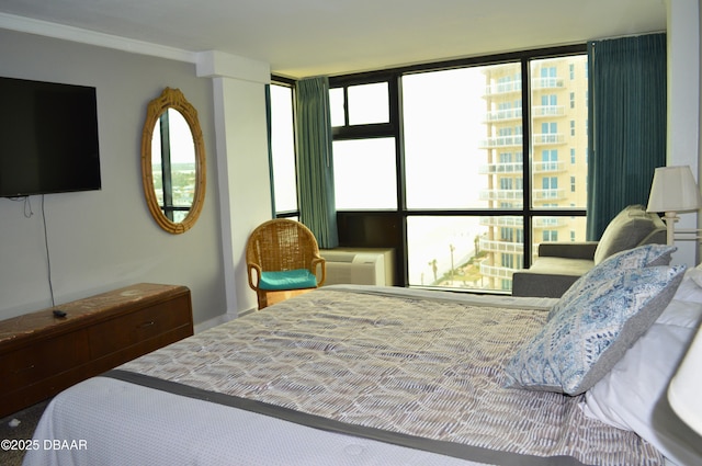 bedroom with ornamental molding and a wall mounted AC