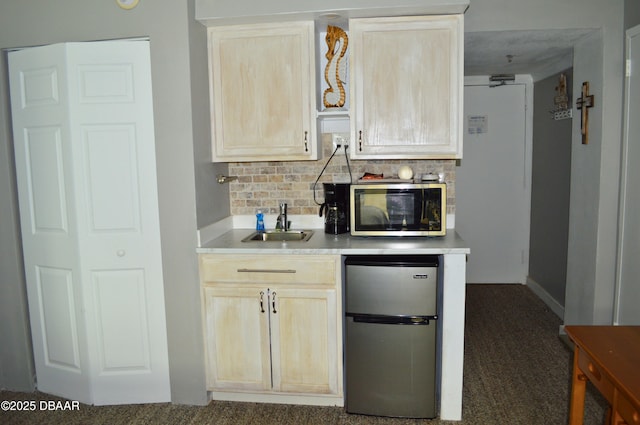 kitchen with appliances with stainless steel finishes, sink, decorative backsplash, dark colored carpet, and light brown cabinets