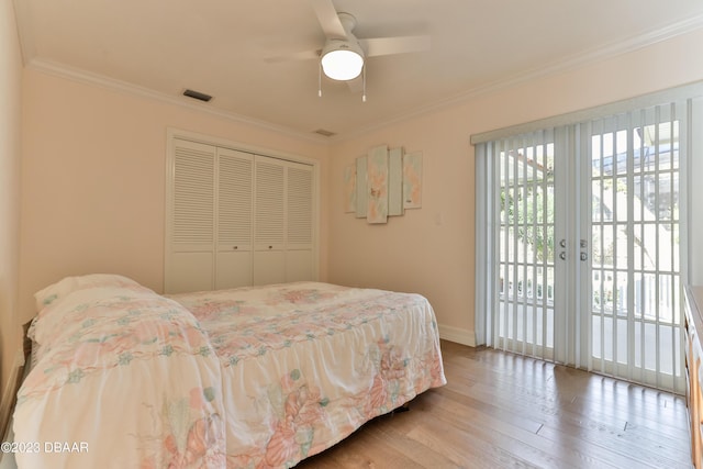 bedroom with access to outside, visible vents, crown molding, and wood finished floors