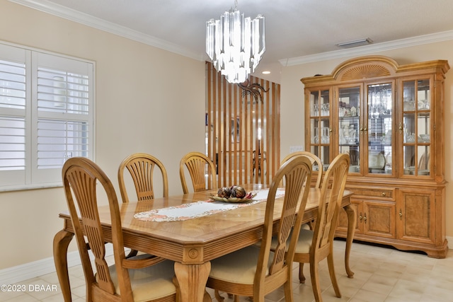 dining space featuring ornamental molding, visible vents, a notable chandelier, and baseboards