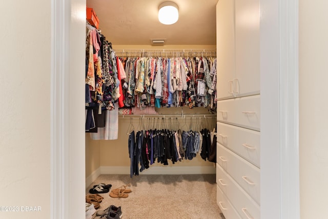 walk in closet featuring light colored carpet