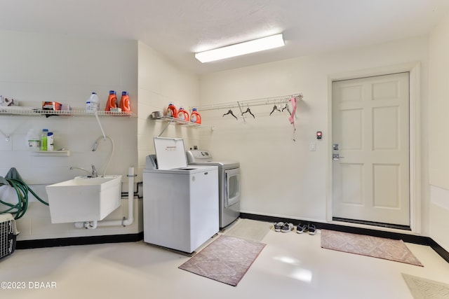 washroom featuring laundry area, independent washer and dryer, and a sink