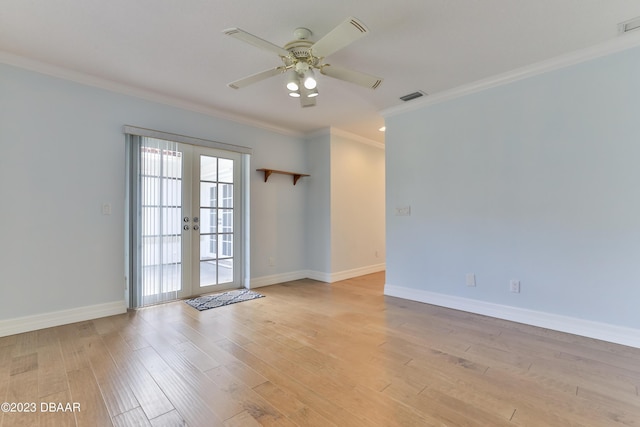 empty room featuring light wood-style flooring, visible vents, baseboards, ornamental molding, and french doors