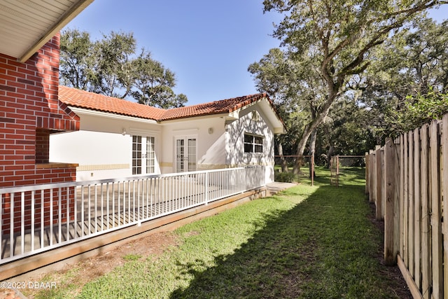 view of yard featuring a fenced backyard and french doors