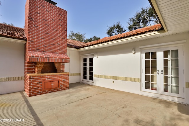 view of patio with a fireplace and french doors