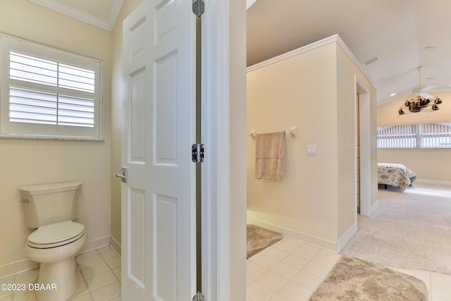 bathroom with toilet, tile patterned flooring, baseboards, and crown molding