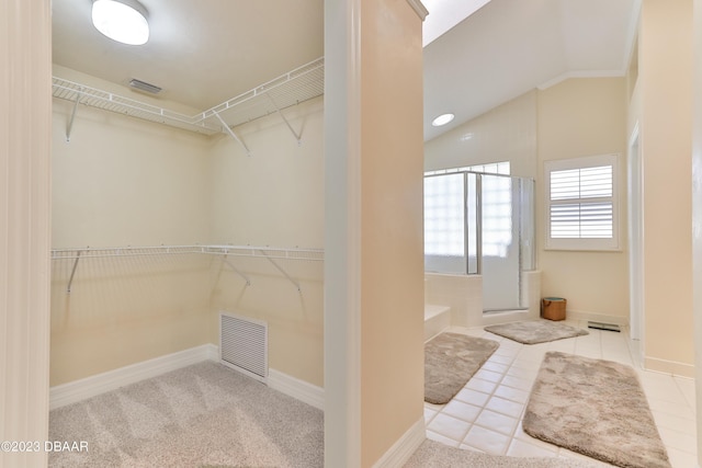 spacious closet featuring visible vents, vaulted ceiling, and tile patterned floors