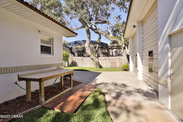 view of patio / terrace with a lanai and fence