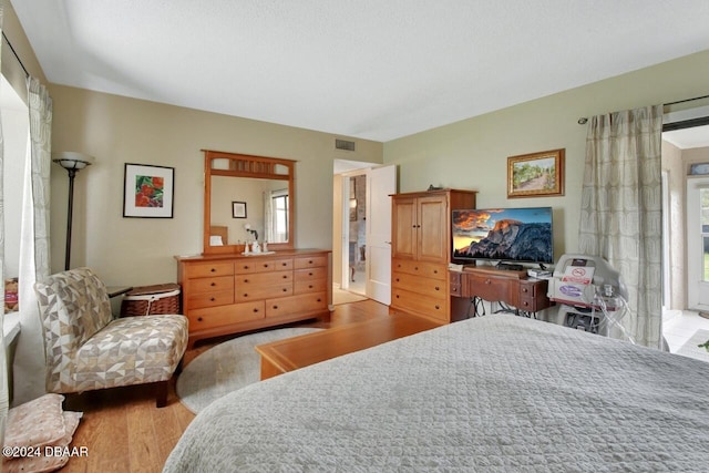 bedroom with multiple windows and light hardwood / wood-style flooring