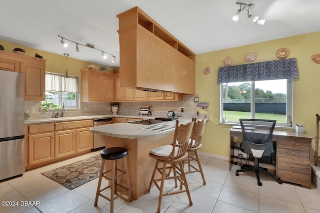 kitchen with tasteful backsplash, light brown cabinets, and appliances with stainless steel finishes