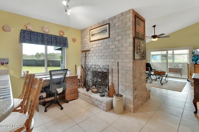 home office featuring light tile patterned floors, a brick fireplace, ceiling fan, and lofted ceiling