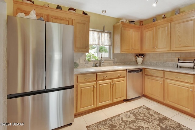 kitchen with tasteful backsplash, sink, pendant lighting, and appliances with stainless steel finishes