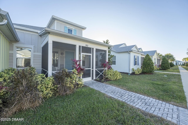 view of front of home featuring a sunroom and a front yard