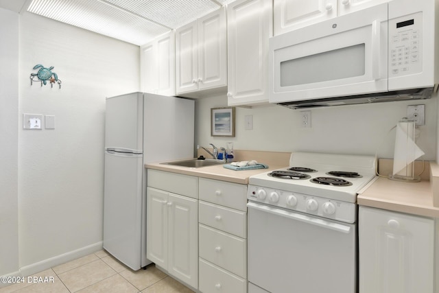 kitchen with sink, white appliances, light tile patterned floors, and white cabinets